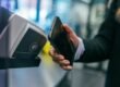 person som bruker kontaktløs betaling med mobil på kortterminal