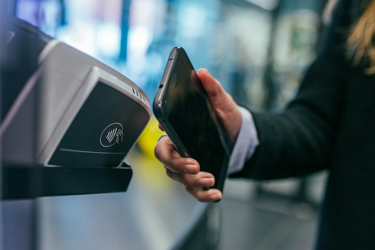 person som bruker kontaktløs betaling med mobil på kortterminal