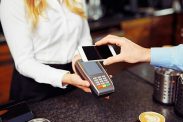 person betaler med mobilbetaling i butikk